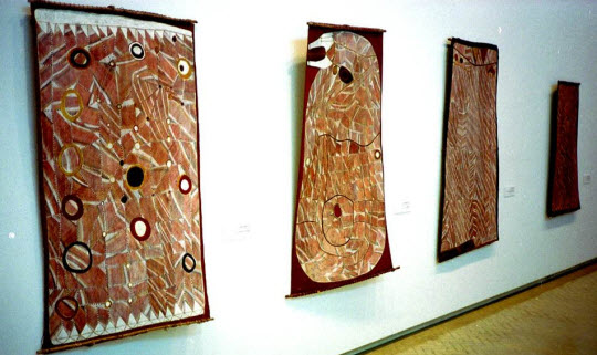 Four bark paintings in ocher tones.