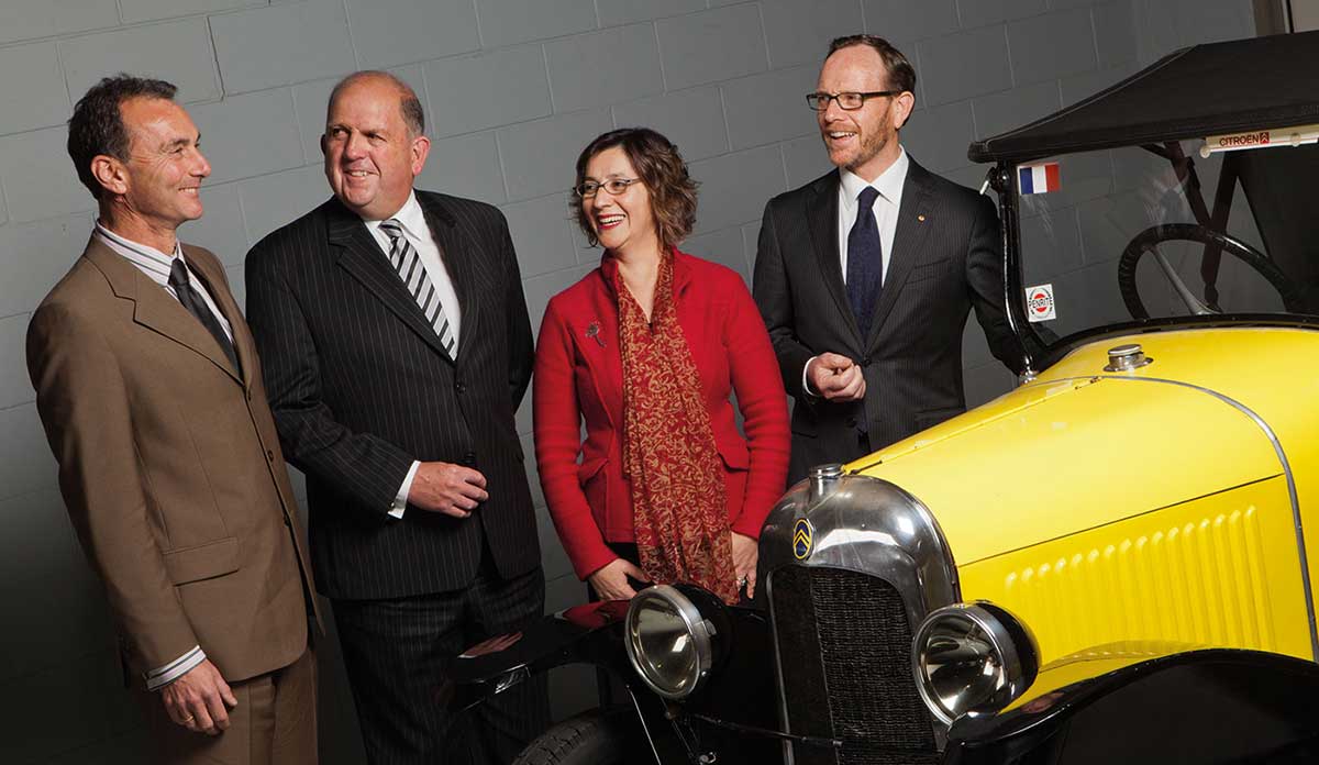 The Executive of the National Museum of Australia standing beside a vintage car.
