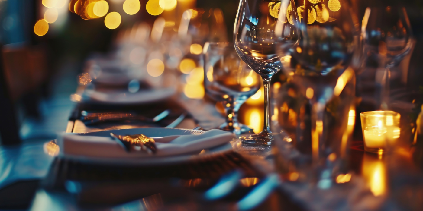 Table setting with glassware and small candles, AI-generated stock image from Adobe.