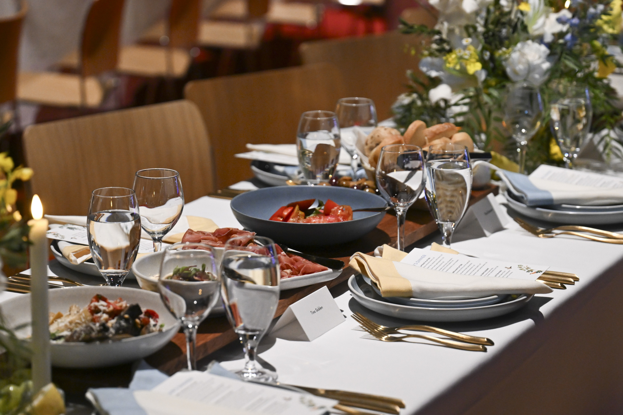 A long table with multiple settings, with shared plates at the centre.