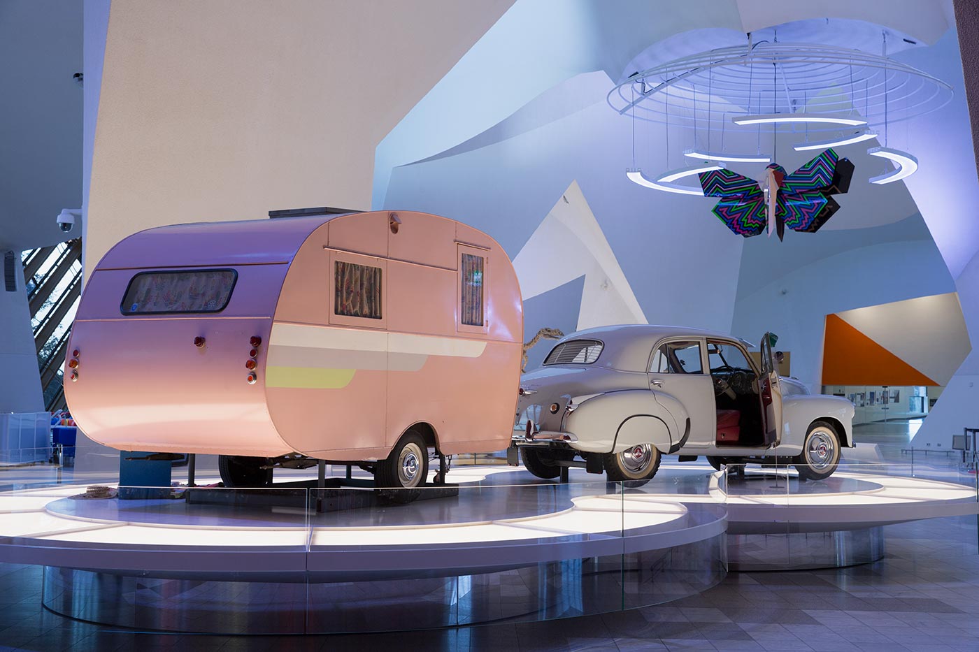 An FJ Holden and pink Propert caravan on display inside the National Museum of Australia.