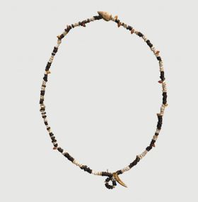 Necklace consisting of flat white shells, brown wooden discs, small red snail shells, one larger snail shell, and one tooth arranged on string.