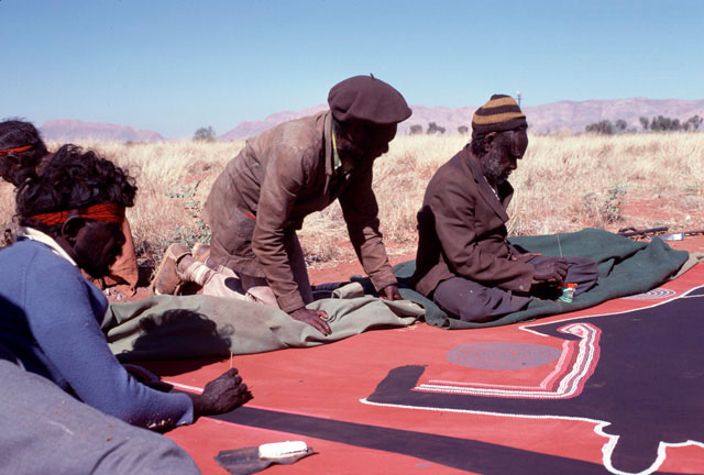 Men working on painting in desert.