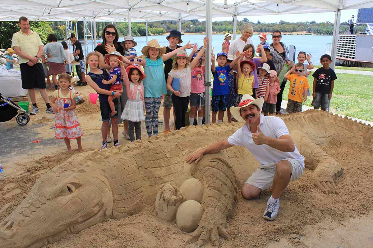 Sand sculptor Tutti Bonacci poses with his creation in front of an enthusiastic group of supporters, 26 January 2014.
